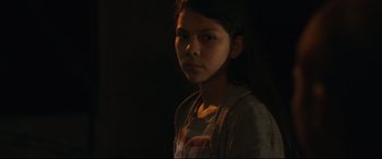Movie still from “Tigers Are Not Afraid” (2017), directed by Issa López – A young girl is standing in a dark room; Close Up shot, Over the shoulder angle