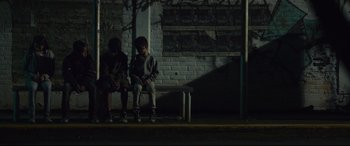 Movie still from “Tigers Are Not Afraid” (2017), directed by Issa López – Two young boys sitting on a park bench at night; Wide shot, High angle