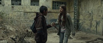Movie still from “Tigers Are Not Afraid” (2017), directed by Issa López – Two young people are shaking hands in an abandoned building; Medium shot, Low angle