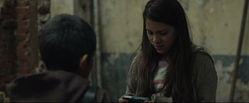 Movie still from “Tigers Are Not Afraid” (2017), directed by Issa López – A young girl is looking at her cell phone; Close Up shot, Over the shoulder angle