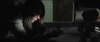 Movie still from “Tigers Are Not Afraid” (2017), directed by Issa López – A woman is looking at her cell phone in the dark; Close Up shot, High angle