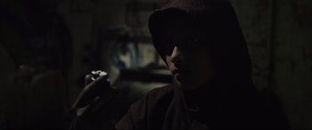 Movie still from “Tigers Are Not Afraid” (2017), directed by Issa López – A man in a hooded sweatshirt is smoking a cigarette; Close Up shot, High angle