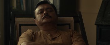 Movie still from “Tirandaj Shabor” (2022), directed by Arindam Sil – A person with a mustache; Close Up shot, Low angle