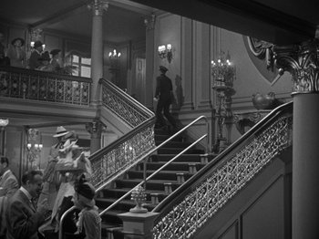 Movie still from “Titanic” (1953), directed by Jean Negulesco – A black - and - white photo of people walking up and down stairs; Wide shot, High angle