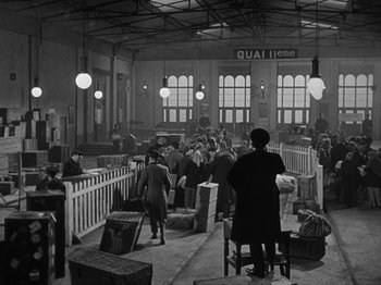 Movie still from “Titanic” (1953), directed by Jean Negulesco – A black and white photo of people waiting at a train station; Wide shot, High angle