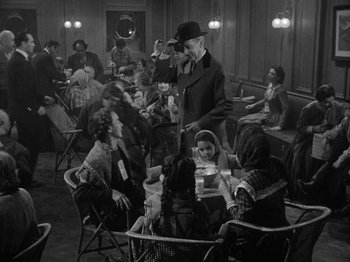 Movie still from “Titanic” (1953), directed by Jean Negulesco – A group of people sitting around a table; Wide shot, High angle