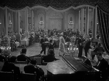 Movie still from “Titanic” (1953), directed by Jean Negulesco – An old photo of people sitting at tables in a restaurant; Extreme Wide shot, High angle