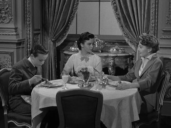 Movie still from “Titanic” (1953), directed by Jean Negulesco – A group of people sitting at a table with plates of food; Medium shot, High angle