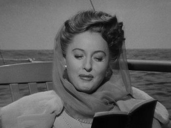 Movie still from “Titanic” (1953), directed by Jean Negulesco – A black and white photo of a woman reading a book on a sailboat; Close Up shot, Low angle