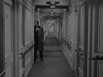 Movie still from “Titanic” (1953), directed by Jean Negulesco – A black and white photo of a man in a long hallway; Wide shot, High angle