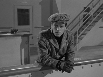 Movie still from “Titanic” (1953), directed by Jean Negulesco – A black and white photo of a man leaning on a railing; Medium shot, High angle