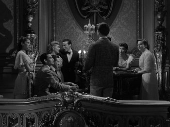 Movie still from “Titanic” (1953), directed by Jean Negulesco – A group of people standing around a table; Wide shot, High angle