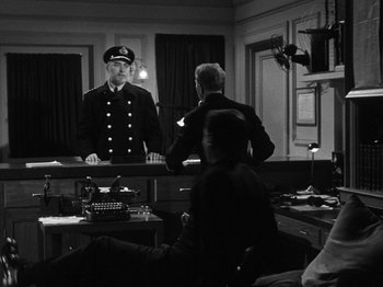 Movie still from “Titanic” (1953), directed by Jean Negulesco – A man in a uniform standing in front of a mirror; Wide shot, Over the shoulder angle