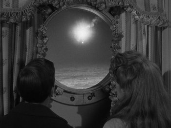 Movie still from “Titanic” (1953), directed by Jean Negulesco – Two people looking out a porthole at the sun; Medium shot, High angle