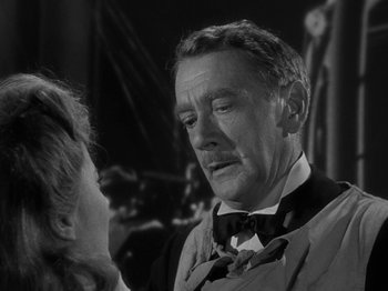 Movie still from “Titanic” (1953), directed by Jean Negulesco – An older man in a suit and bow tie talking to a woman in a black dress; Close Up shot, Over the shoulder angle