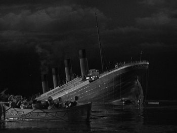 Movie still from “Titanic” (1953), directed by Jean Negulesco – A black - and - white photo of a boat in the water near a ship; Extreme Wide shot, Low angle