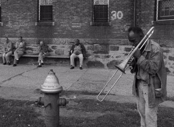 A man playing a trombone near a fire hydrant