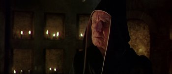 Movie still from “Titus” (1999), directed by Julie Taymor – An old man wearing a black robe and a black hood; Close Up shot, Over the shoulder angle