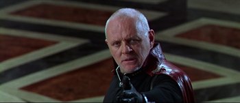 Movie still from “Titus” (1999), directed by Julie Taymor – An older man in a black shirt and a black leather jacket; Close Up shot, Low angle