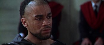 Movie still from “Titus” (1999), directed by Julie Taymor – A person with a face tattoo; Close Up shot, High angle