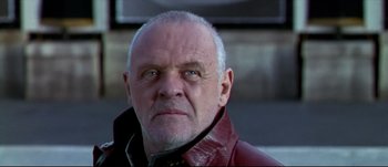 Movie still from “Titus” (1999), directed by Julie Taymor – An older man wearing a leather jacket looking at the camera; Close Up shot, Low angle