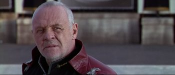 Movie still from “Titus” (1999), directed by Julie Taymor – An older man wearing a red leather jacket; Close Up shot, Low angle