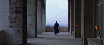 Movie still from “Titus” (1999), directed by Julie Taymor – A man walking through an archway towards a window; Extreme Wide shot, Low angle