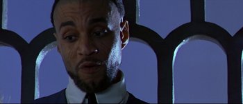 Movie still from “Titus” (1999), directed by Julie Taymor – A person wearing a suit and tie; Close Up shot, Low angle