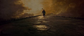 Movie still from “Titus” (1999), directed by Julie Taymor – A person walking on a path in the middle of the night; Extreme Wide shot, High angle