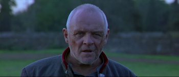 Movie still from “Titus” (1999), directed by Julie Taymor – An older man with a goatee looking at the camera; Close Up shot, Low angle