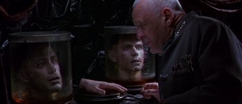 Movie still from “Titus” (1999), directed by Julie Taymor – An older man looking at a mirror with a man's face in it; Close Up shot, Over the shoulder angle