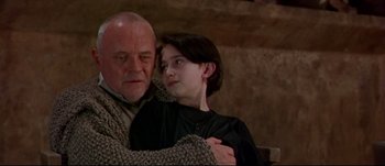Movie still from “Titus” (1999), directed by Julie Taymor – An older man and a young woman embracing each other; Close Up shot, Low angle
