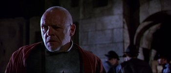 Movie still from “Titus” (1999), directed by Julie Taymor – An old man with a beard and a red jacket; Close Up shot, Low angle