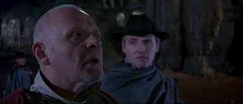 Movie still from “Titus” (1999), directed by Julie Taymor – A man in a hat and a man in a hat and a man with a beard; Close Up shot, Low angle