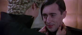 Movie still from “Titus” (1999), directed by Julie Taymor – A man with long black hair is looking at a woman with blonde hair; Close Up shot, Over the shoulder angle