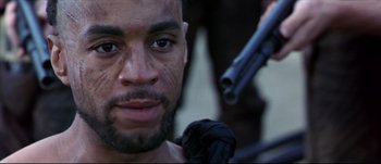 Movie still from “Titus” (1999), directed by Julie Taymor – A person holding a gun; Close Up shot, Over the shoulder angle