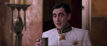 Movie still from “Titus” (1999), directed by Julie Taymor – A man in a white shirt holding a silver cup; Close Up shot, Low angle