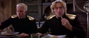 Movie still from “Titus” (1999), directed by Julie Taymor – Two people sitting at a table eating food; Close Up shot, Low angle