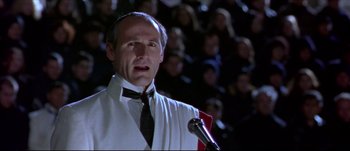 Movie still from “Titus” (1999), directed by Julie Taymor – A man with a microphone in front of an audience; Close Up shot, Low angle