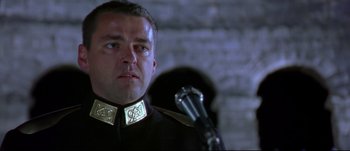 Movie still from “Titus” (1999), directed by Julie Taymor – A person with a microphone; Close Up shot, Low angle