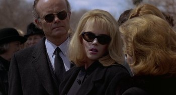 Movie still from “To Die For” (1995), directed by Gus Van Sant – A woman wearing sunglasses and a black jacket; Close Up shot, Over the shoulder angle