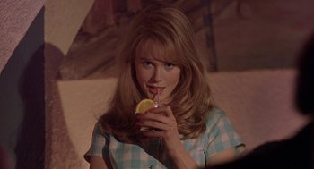 Movie still from “To Die For” (1995), directed by Gus Van Sant – A woman holding a glass of juice with a lemon in her hand; Close Up shot, Over the shoulder angle