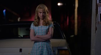 Movie still from “To Die For” (1995), directed by Gus Van Sant – A woman standing in front of a car at night; Medium shot, Low angle