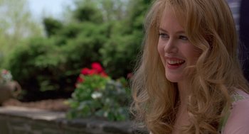Movie still from “To Die For” (1995), directed by Gus Van Sant – A woman with long blonde hair smiling at the camera; Close Up shot, Over the shoulder angle