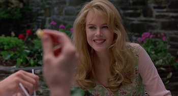 Movie still from “To Die For” (1995), directed by Gus Van Sant – A beautiful young lady smiling for the camera; Close Up shot, Over the shoulder angle