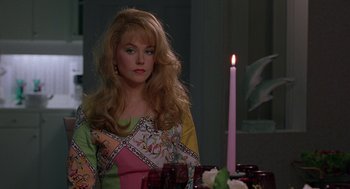 Movie still from “To Die For” (1995), directed by Gus Van Sant – A woman sitting in front of a table with a candle; Medium shot, Over the shoulder angle