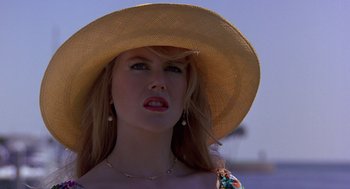 Movie still from “To Die For” (1995), directed by Gus Van Sant – A woman wearing a straw hat and a necklace; Close Up shot, Low angle