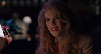 Movie still from “To Die For” (1995), directed by Gus Van Sant – A woman with red lipstick is posing for a picture; Close Up shot, Over the shoulder angle