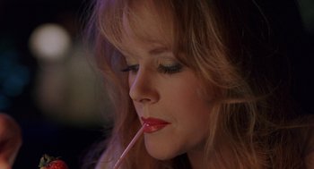 Movie still from “To Die For” (1995), directed by Gus Van Sant – A person holding a straw in her mouth; Close Up shot, High angle