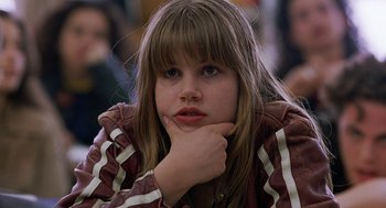 Movie still from “To Die For” (1995), directed by Gus Van Sant – A young girl is sitting with her chin resting on her hand; Close Up shot, Low angle